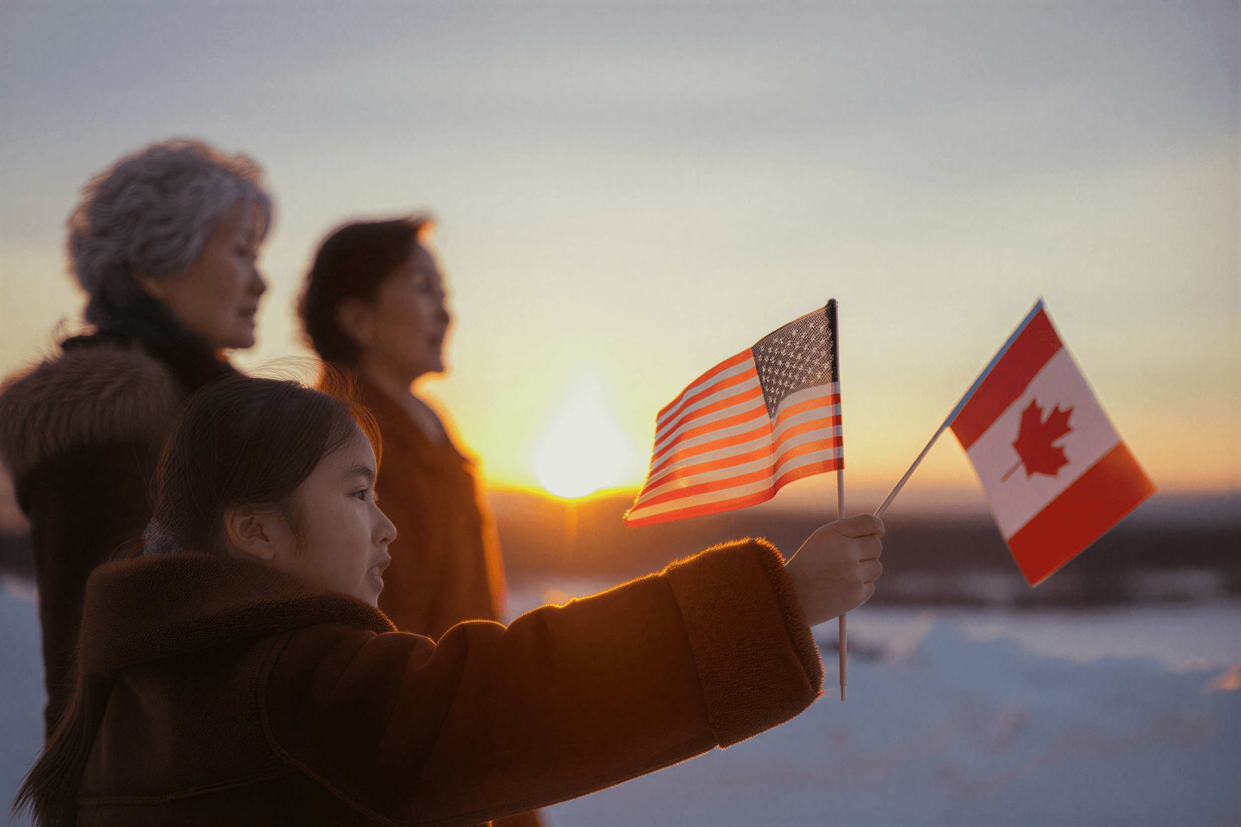 Family holding US and Canadian flags